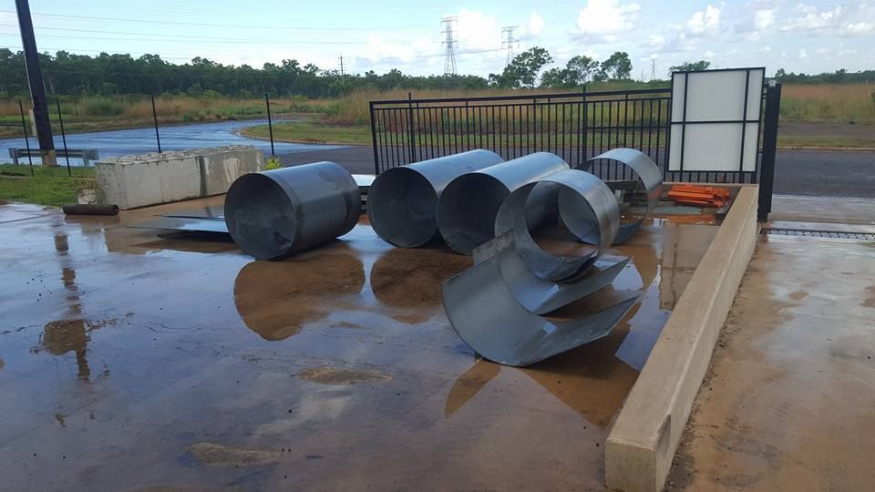 A Bunch of Metal Pipes Are Laying on the Ground — Roll Press NT In Palmerston, NT