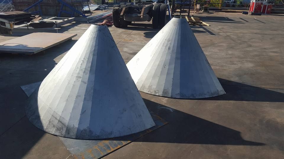 Two metal cones are sitting on top of a concrete surface — Roll Press NT In Kununurra, WA