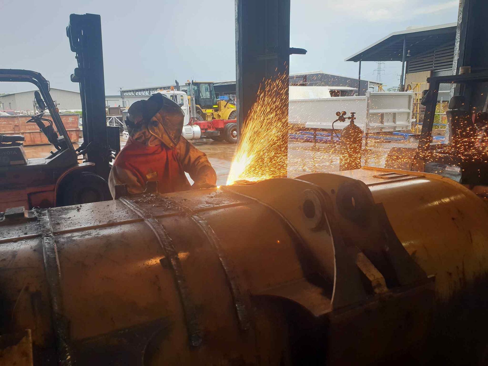 A Man is Welding a Large Piece of Metal in a Factory — Roll Press NT In Tivendale, NT