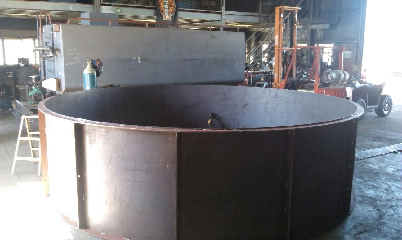 A Large Metal Cylinder is Sitting in a Warehouse Next to a Forklift — Roll Press NT In Alice Springs, NT