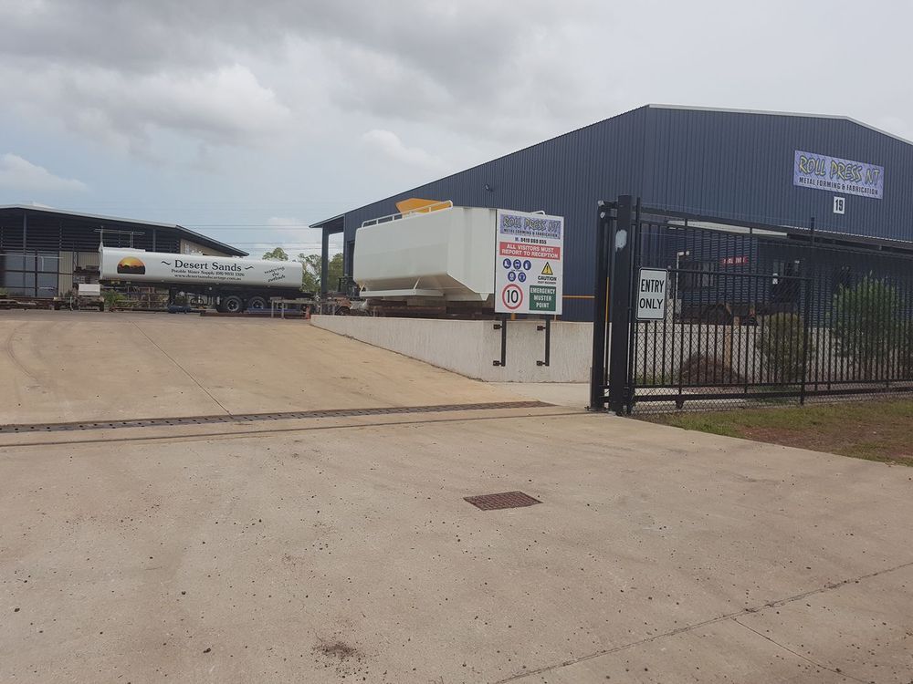 A Truck is Parked in Front of a Large Building — Roll Press NT In Tivendale, NT