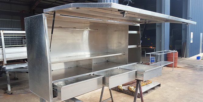 A Large Stainless Steel Cabinet is Sitting on Top of a Wooden Table — Roll Press NT In Tivendale, NT