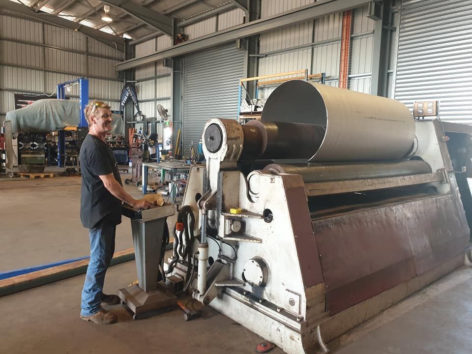 A Man is Working on a Machine in a Factory — Roll Press NT In Tivendale, NT