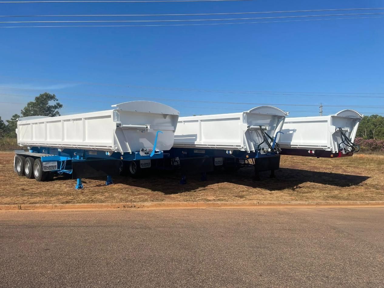 Three White Dump Trailers With Blue Frames Parked On The Side Of A Road Under A Clear Blue Sky — Roll Press NT In Tivendale, NT