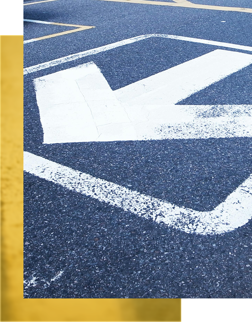 Empty asphalt road with modern office buildings, trees, and blue sky.