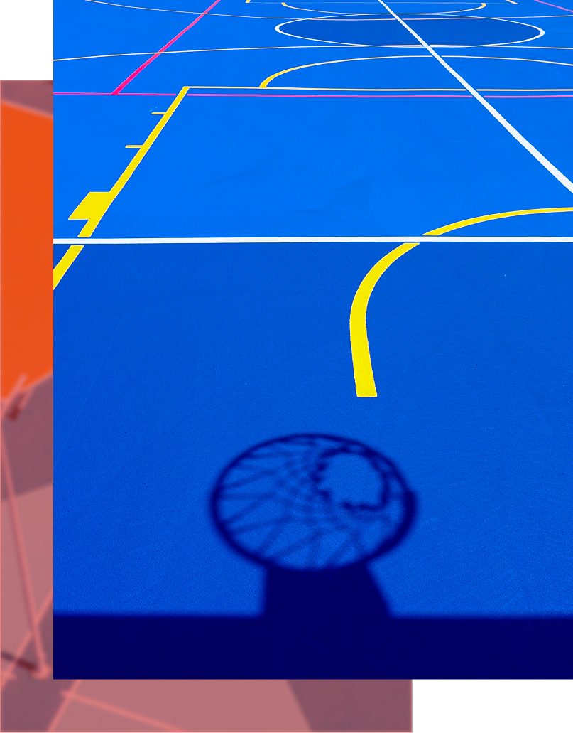 Basketball court with a shadow of a hoop and bright blue court with multiple lines.