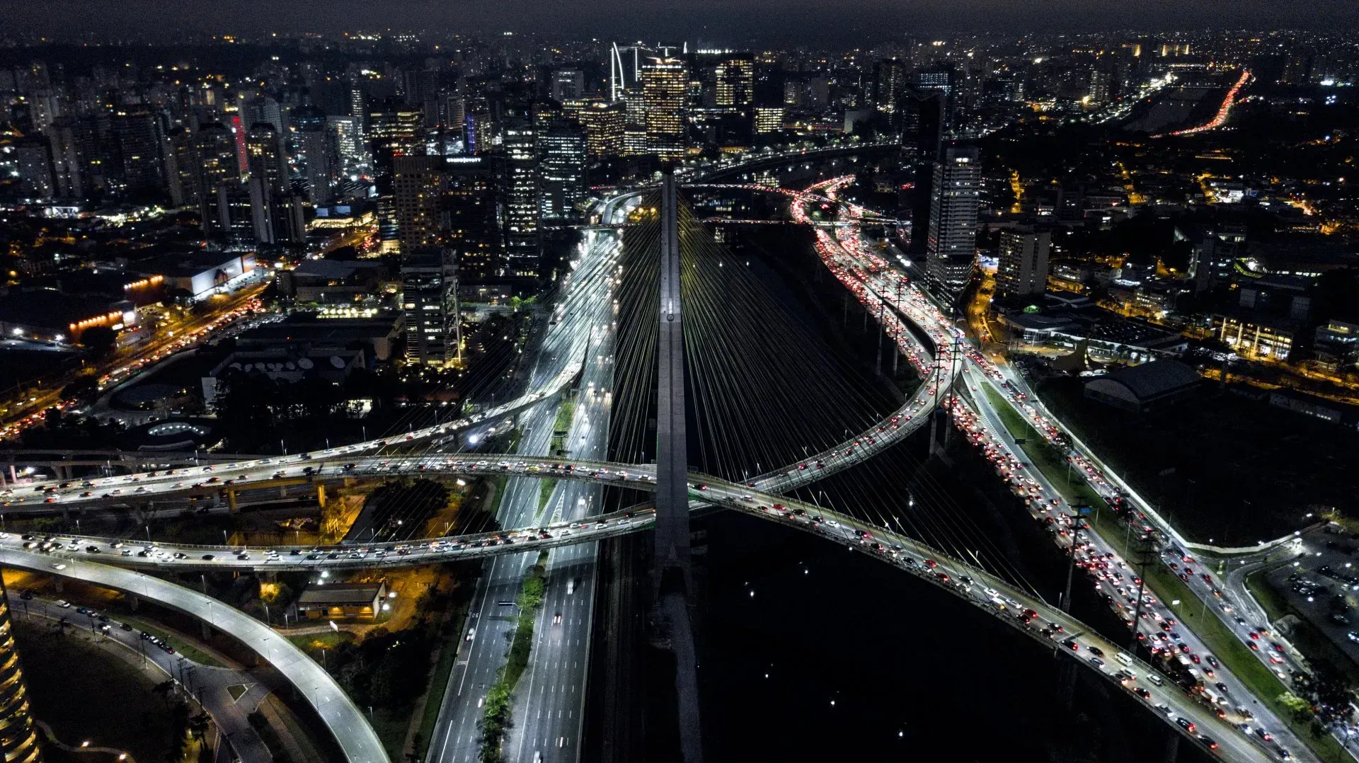 Uma vista aérea de uma ponte sobre um rio à noite.