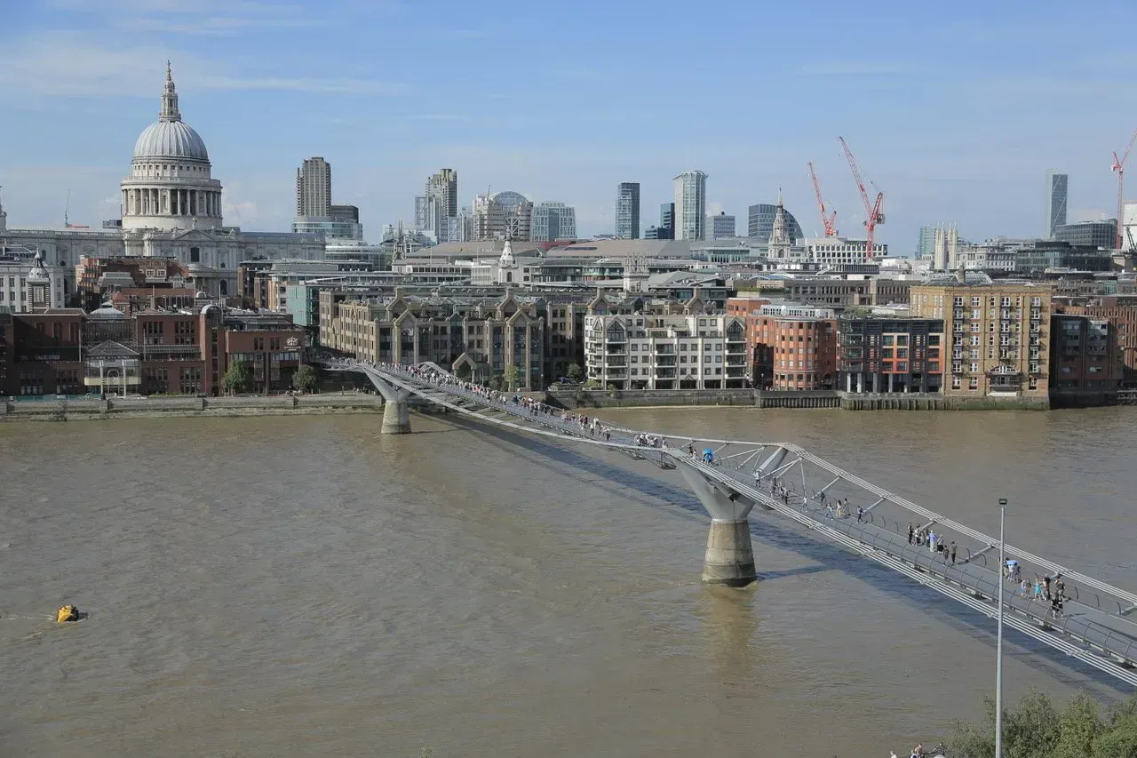 Uma ponte sobre um corpo de água com o horizonte da cidade ao fundo.