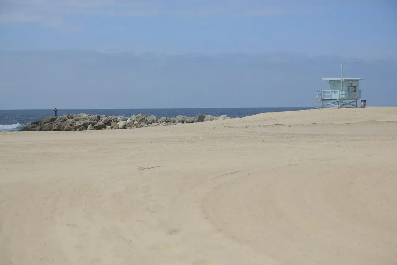 Uma torre de salva-vidas está localizada no topo de uma praia arenosa.