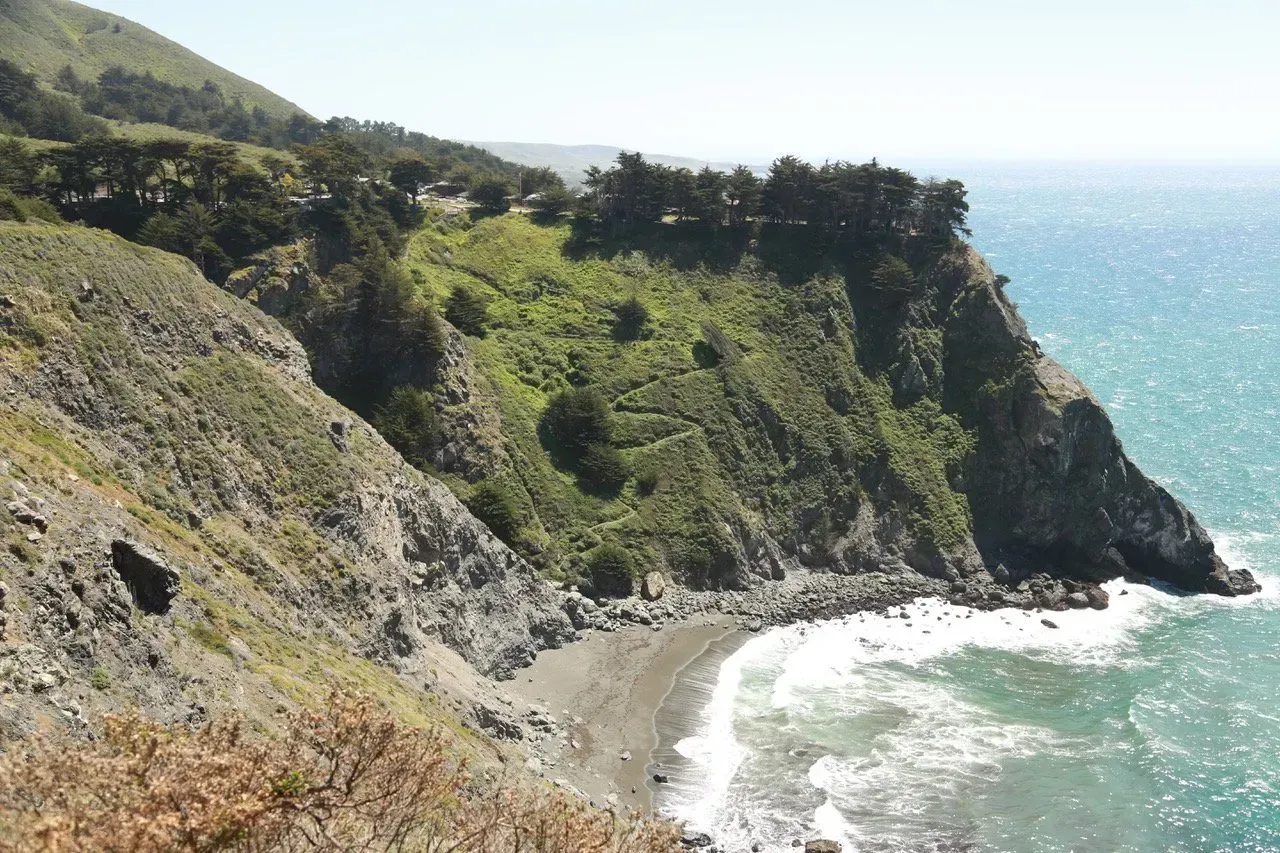 Um penhasco com vista para o oceano com árvores