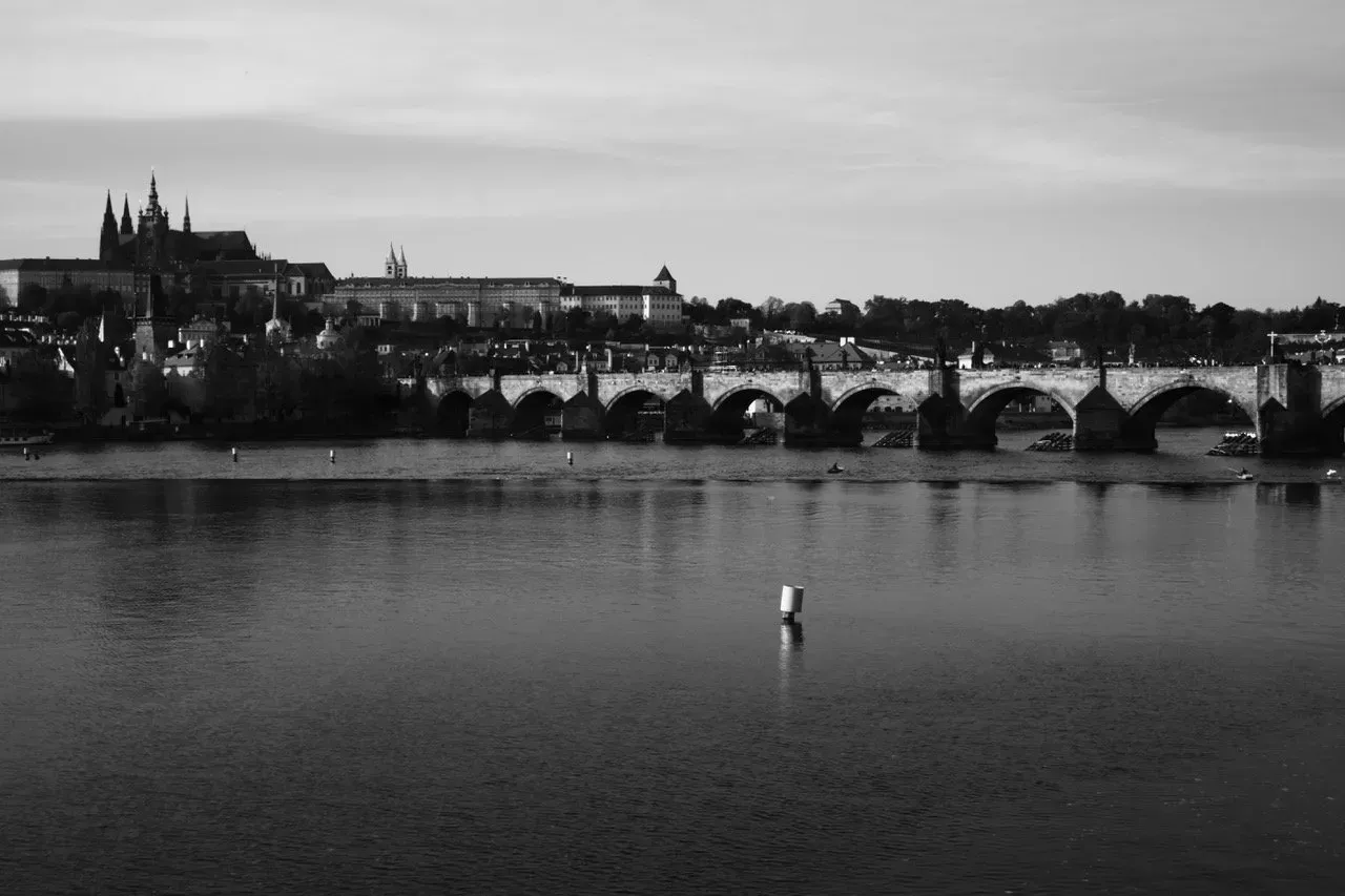 Uma foto em preto e branco de uma ponte sobre um corpo d'água
