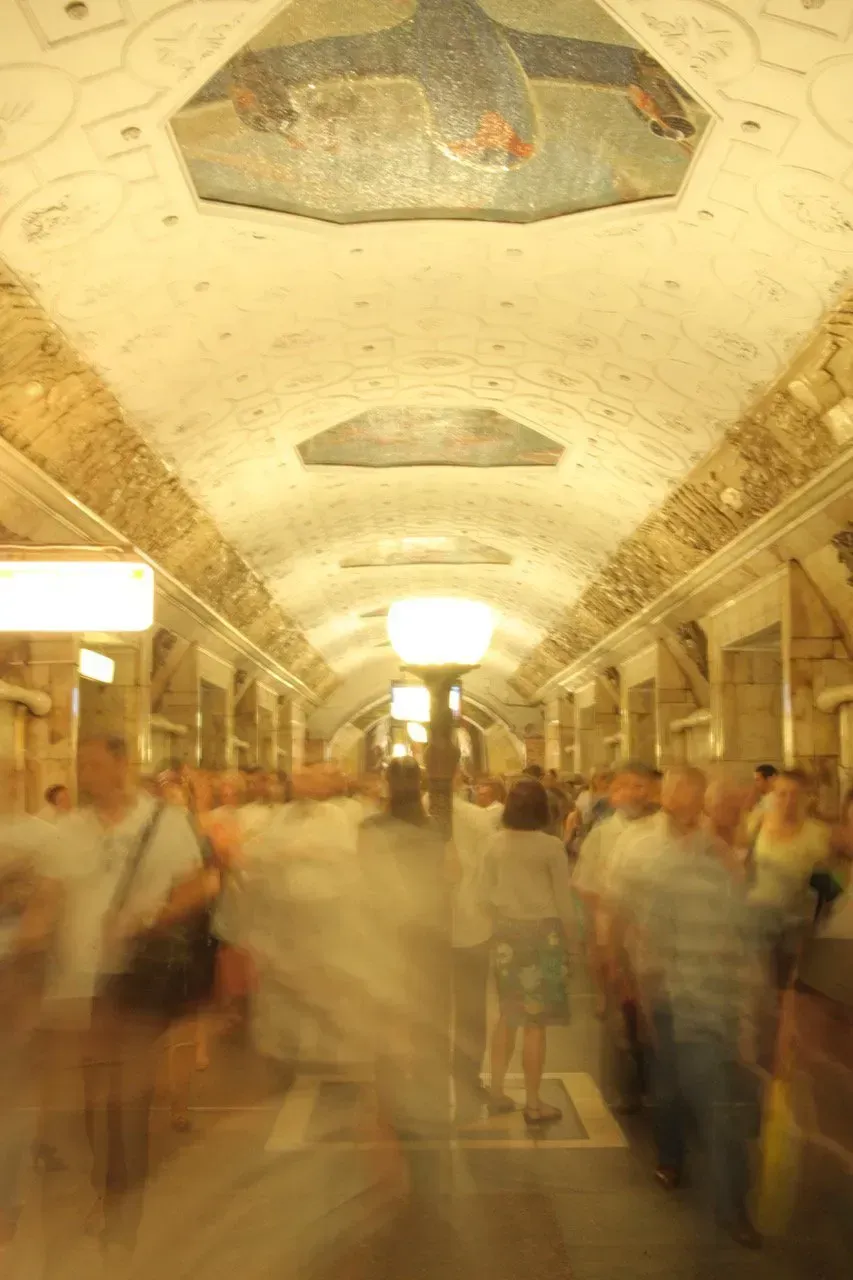 Uma imagem borrada de uma multidão de pessoas caminhando por um corredor.