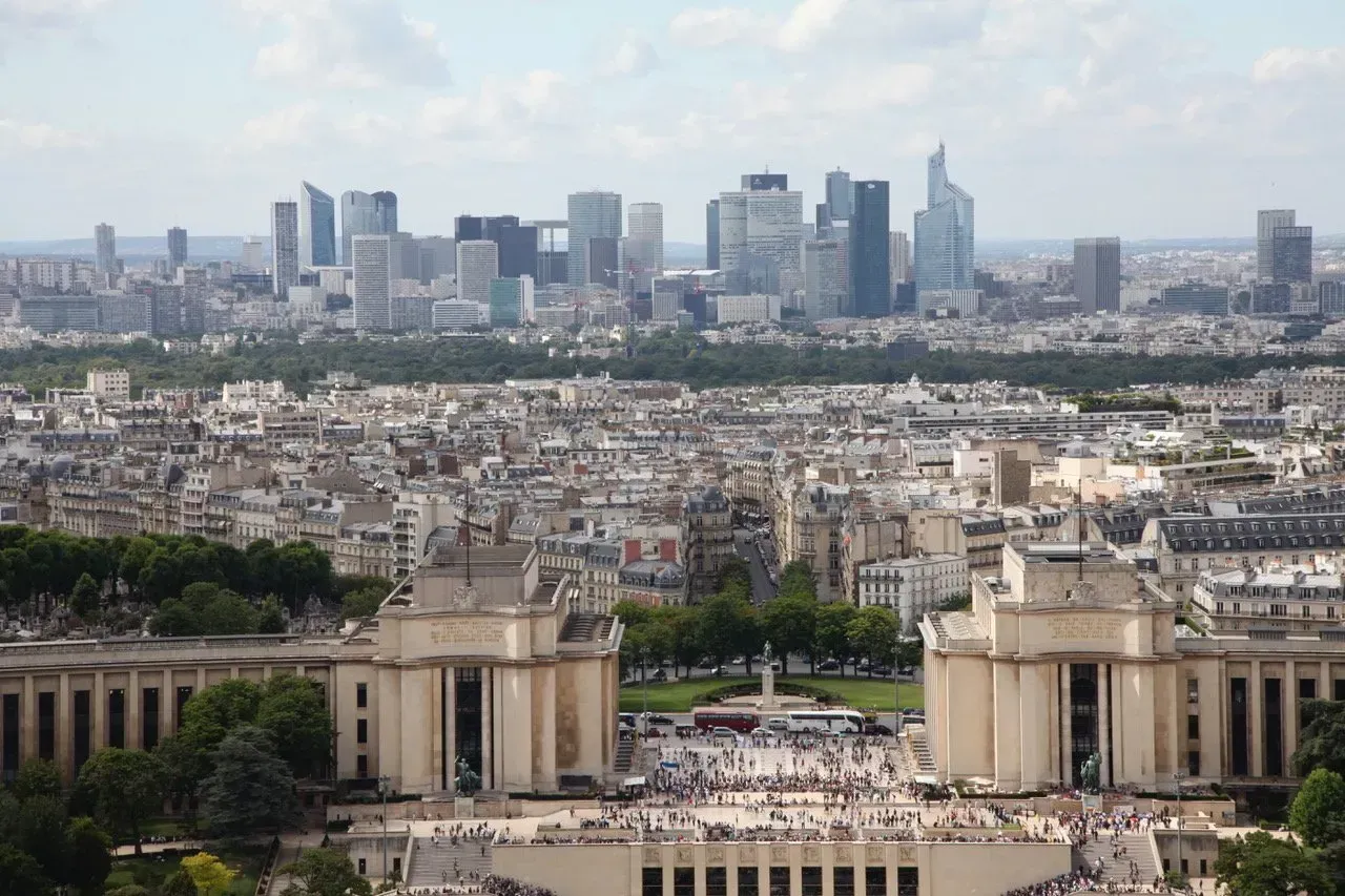Uma vista aérea de uma cidade com um grande edifício em primeiro plano