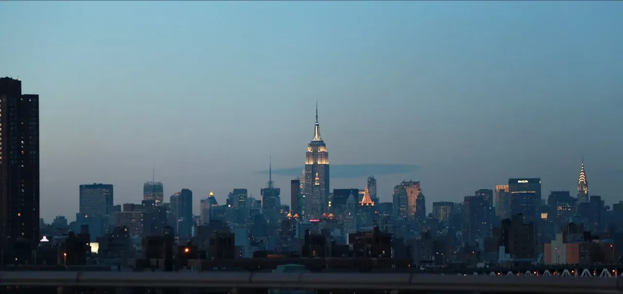 Uma imagem borrada do horizonte de uma cidade à noite com o Empire State Building em primeiro plano.