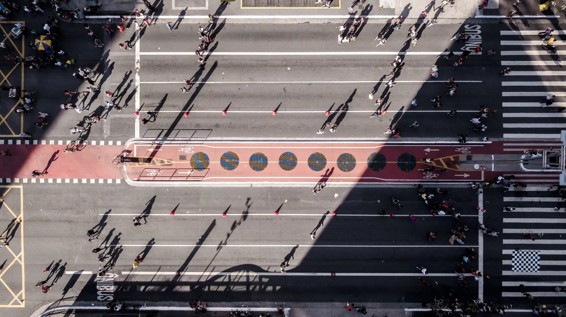 Uma vista aérea de um cruzamento movimentado com pessoas atravessando a rua