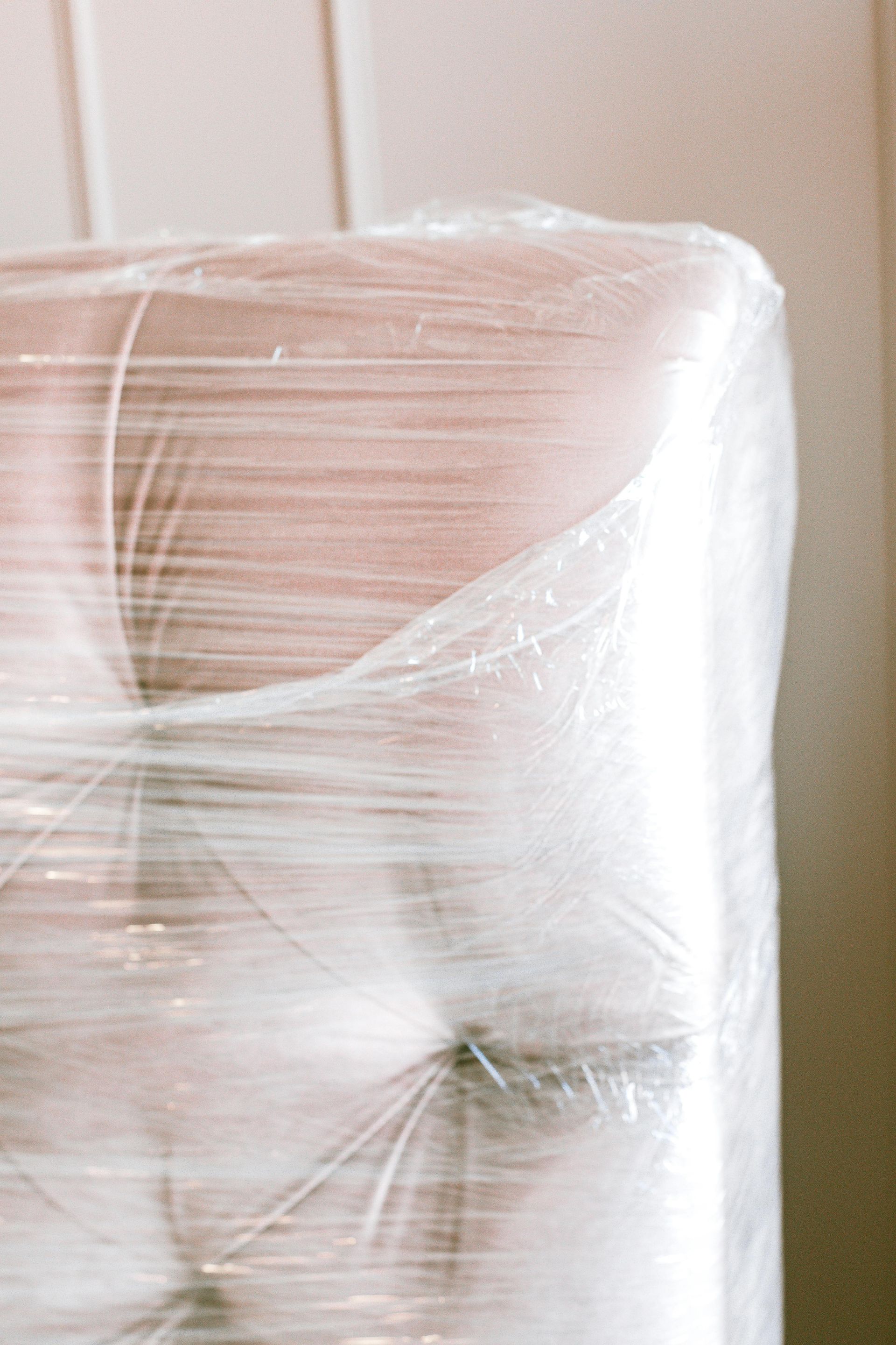 Furniture corner wrapped tightly in clear plastic for protection.