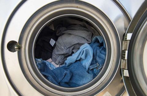 clothes being put for washing in washing machine