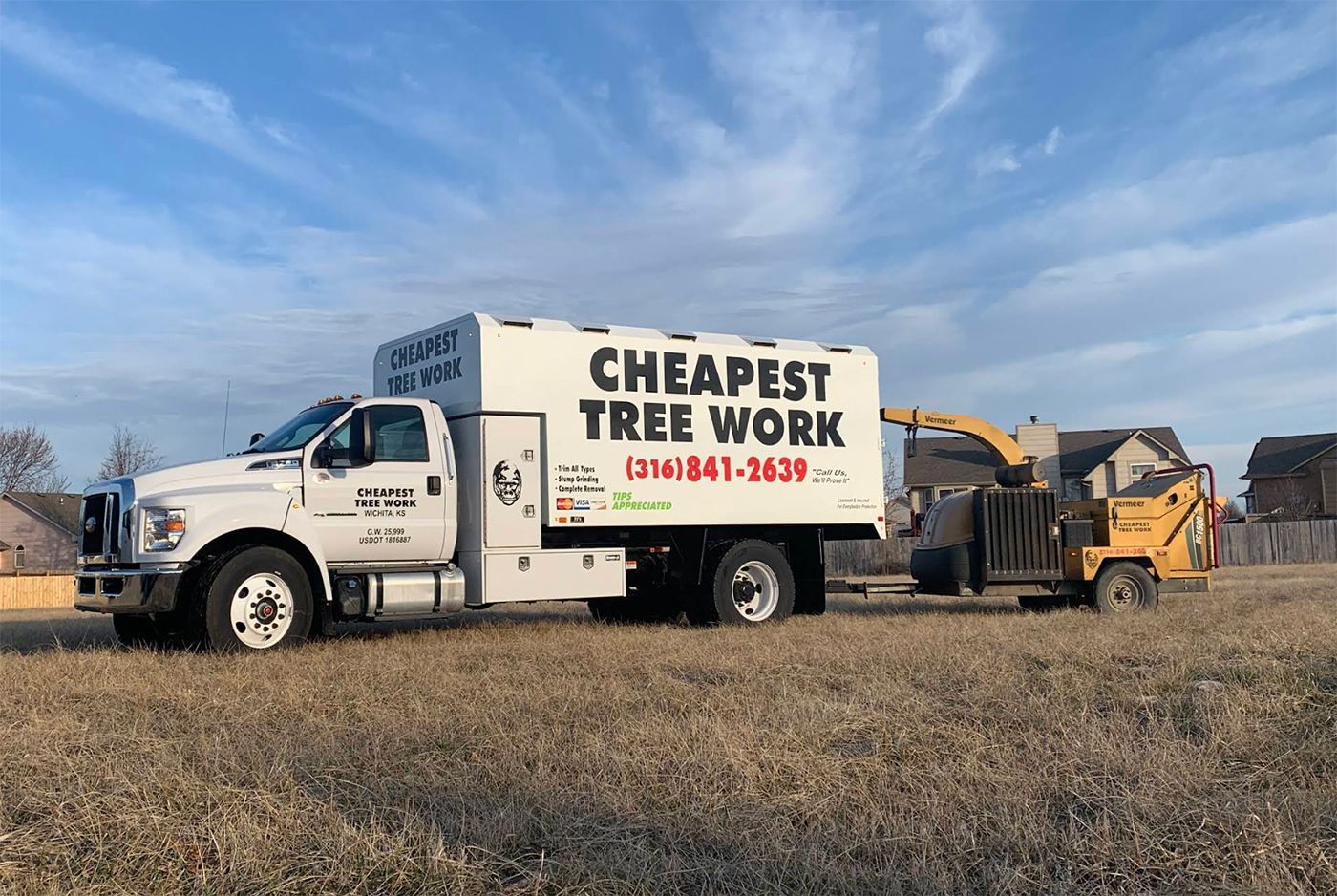 A cheapest tree work truck is parked in a field.