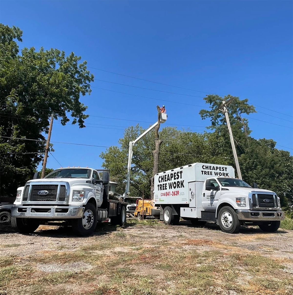 Two trucks are parked next to each other in a dirt lot.
