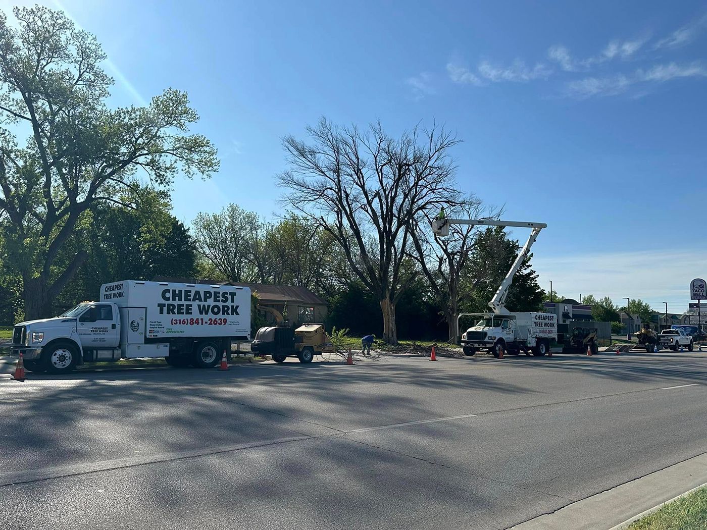 A tree cutting truck is parked on the side of the road.