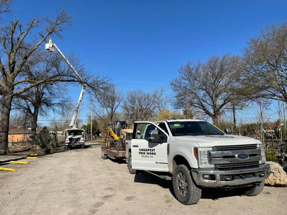 A white truck is parked on the side of the road next to a crane.