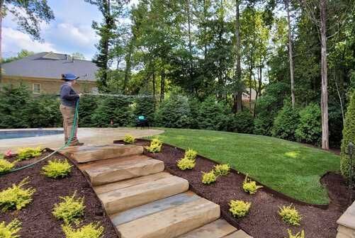 A man is standing on a set of stairs in a backyard.