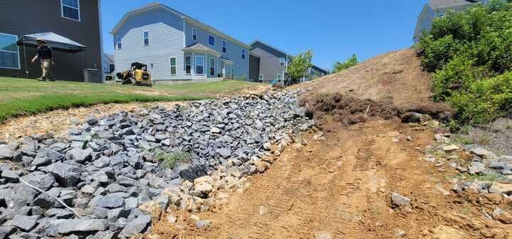 A pile of rocks and dirt in front of a house.