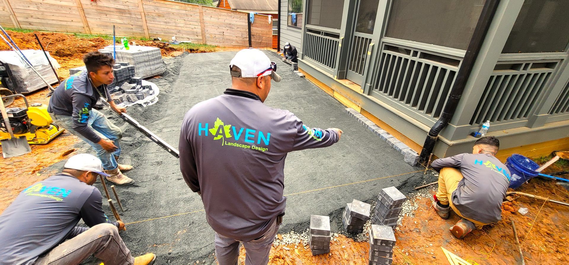 A home in Charlotte, NC getting a stone patio installation - Haven Landscape Design hard at work.