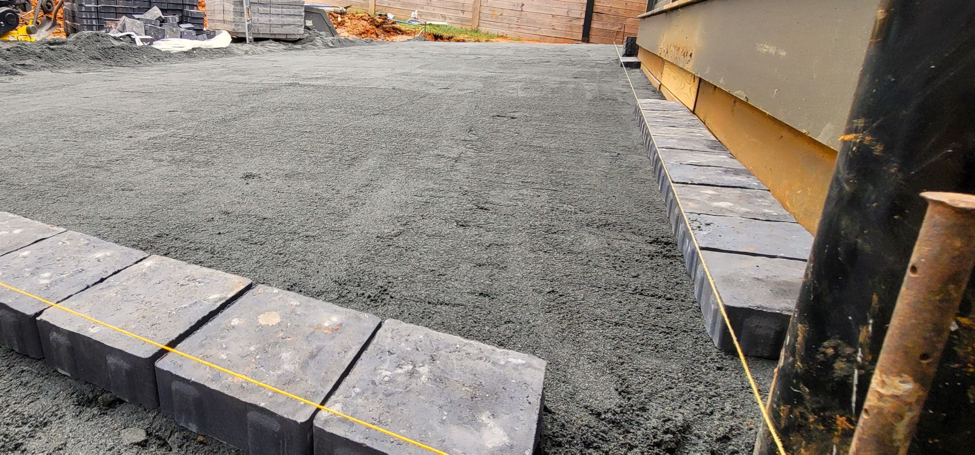 A home in Charlotte, NC getting a stone patio installation - Haven Landscape Design hard at work.