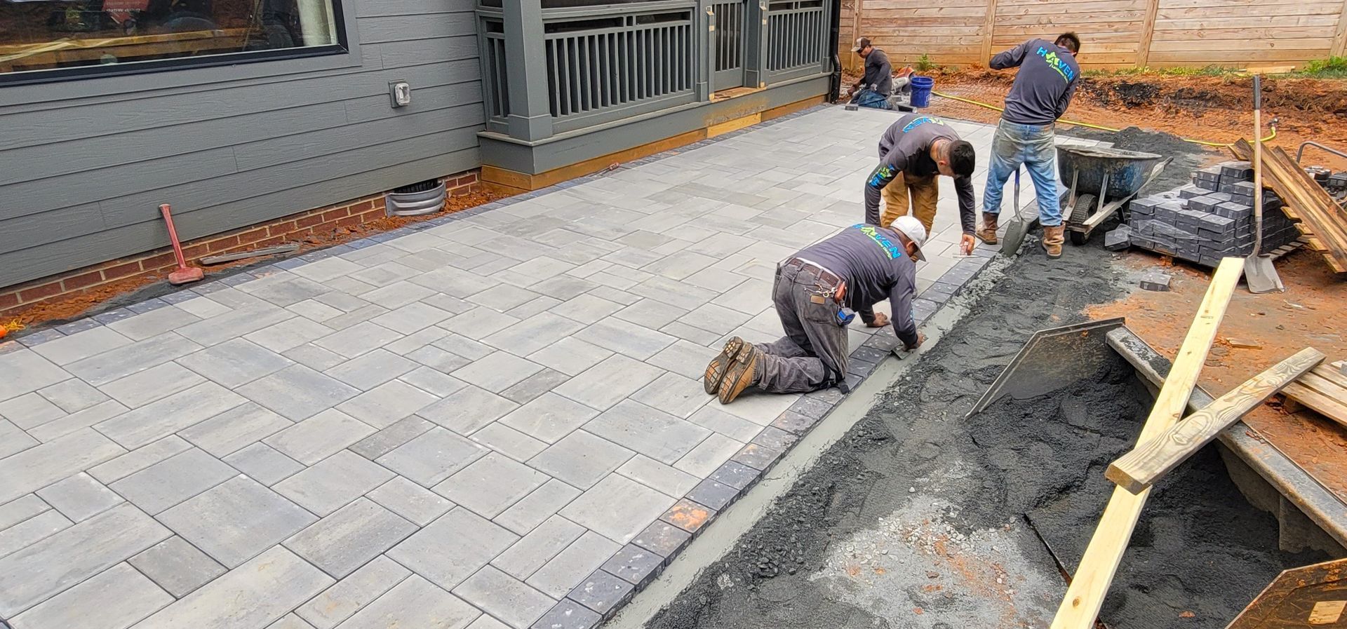 A home in Charlotte, NC getting a stone patio installation - Haven Landscape Design hard at work.