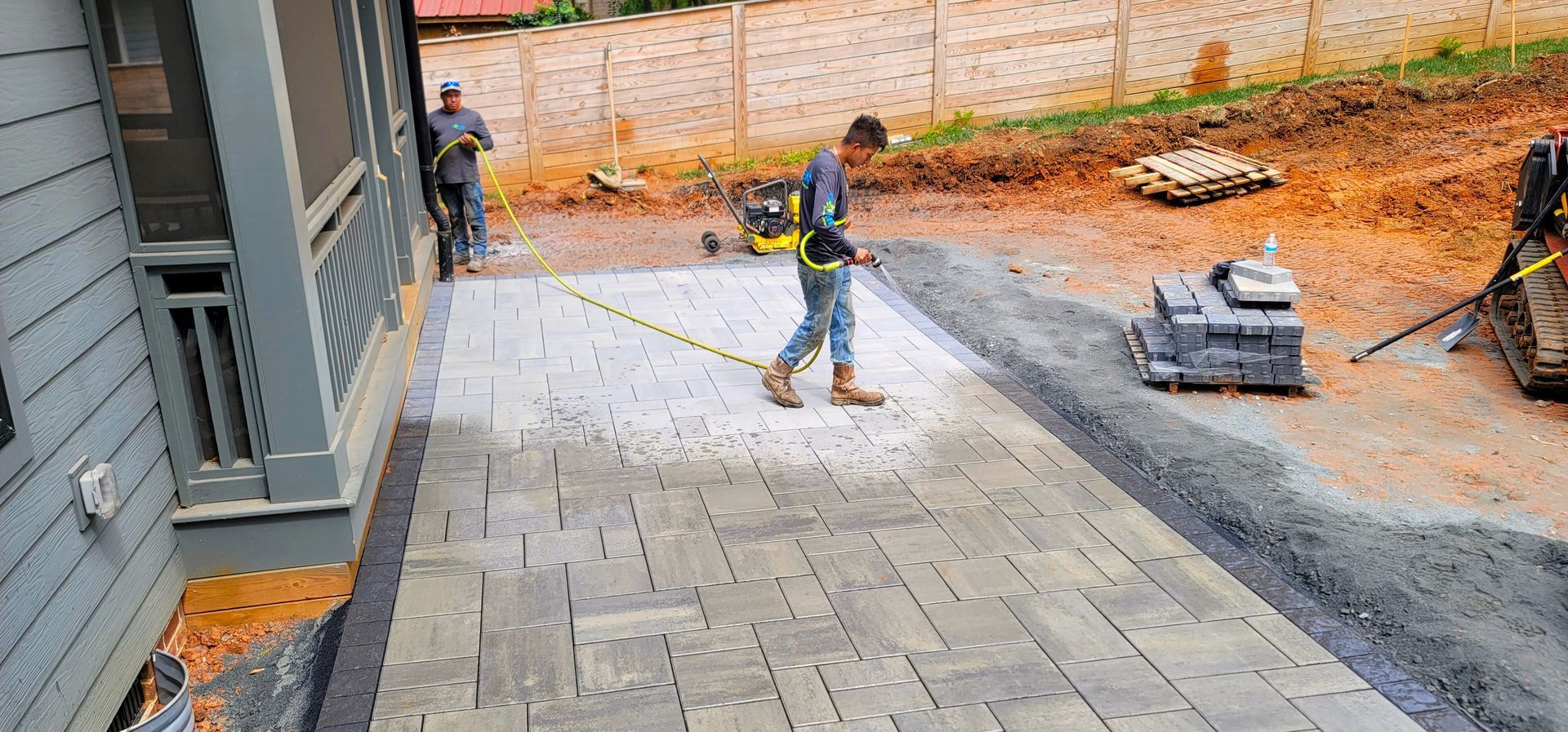 A home in Charlotte, NC getting a stone patio installation - Haven Landscape Design hard at work.