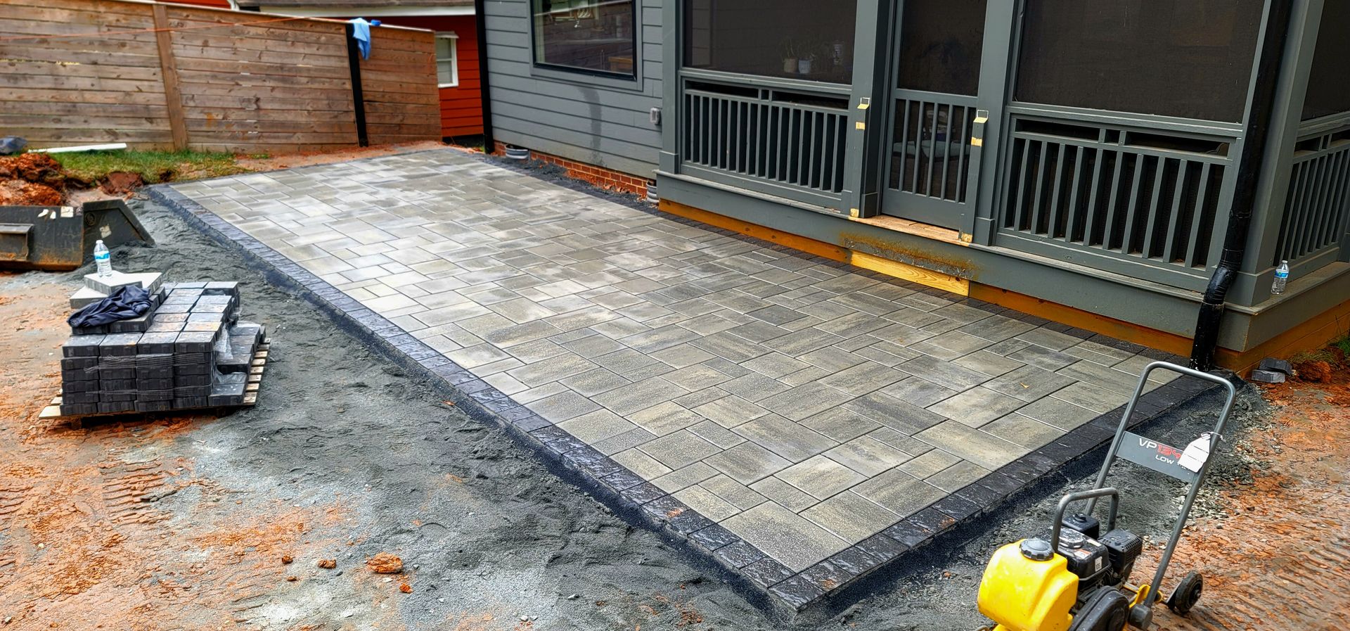 A home in Charlotte, NC getting a stone patio installation - Haven Landscape Design hard at work.