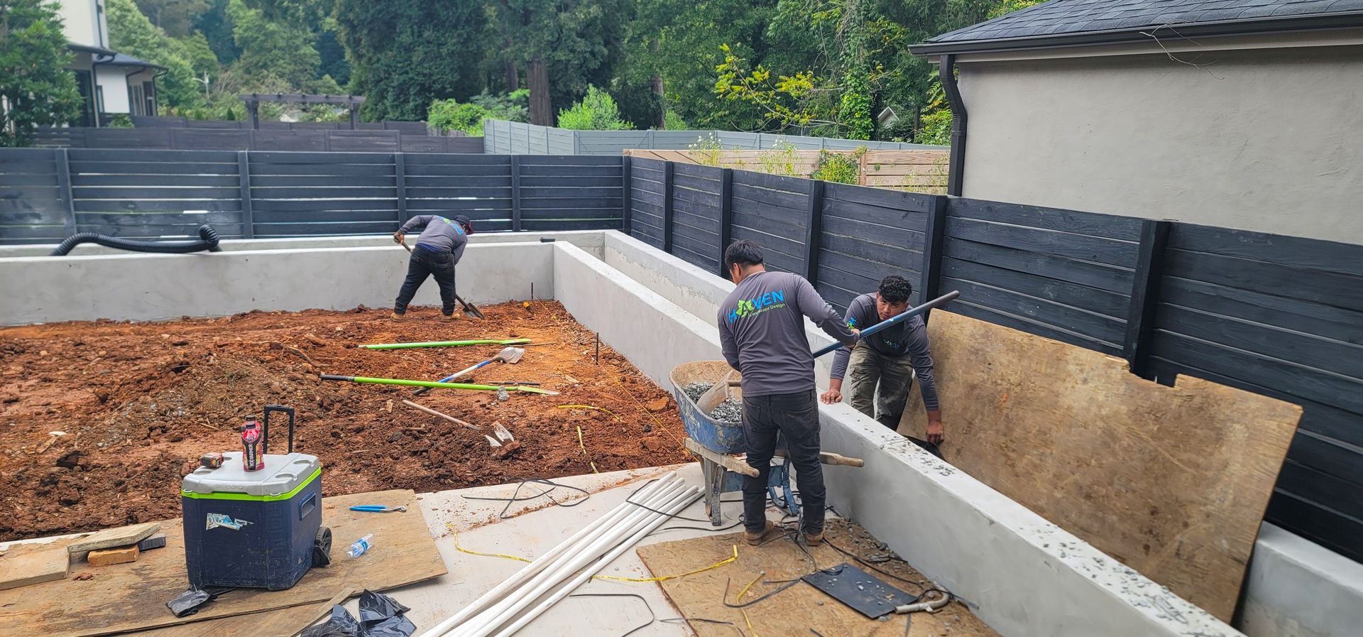 A drain pipe is being installed in the dirt next to a house.