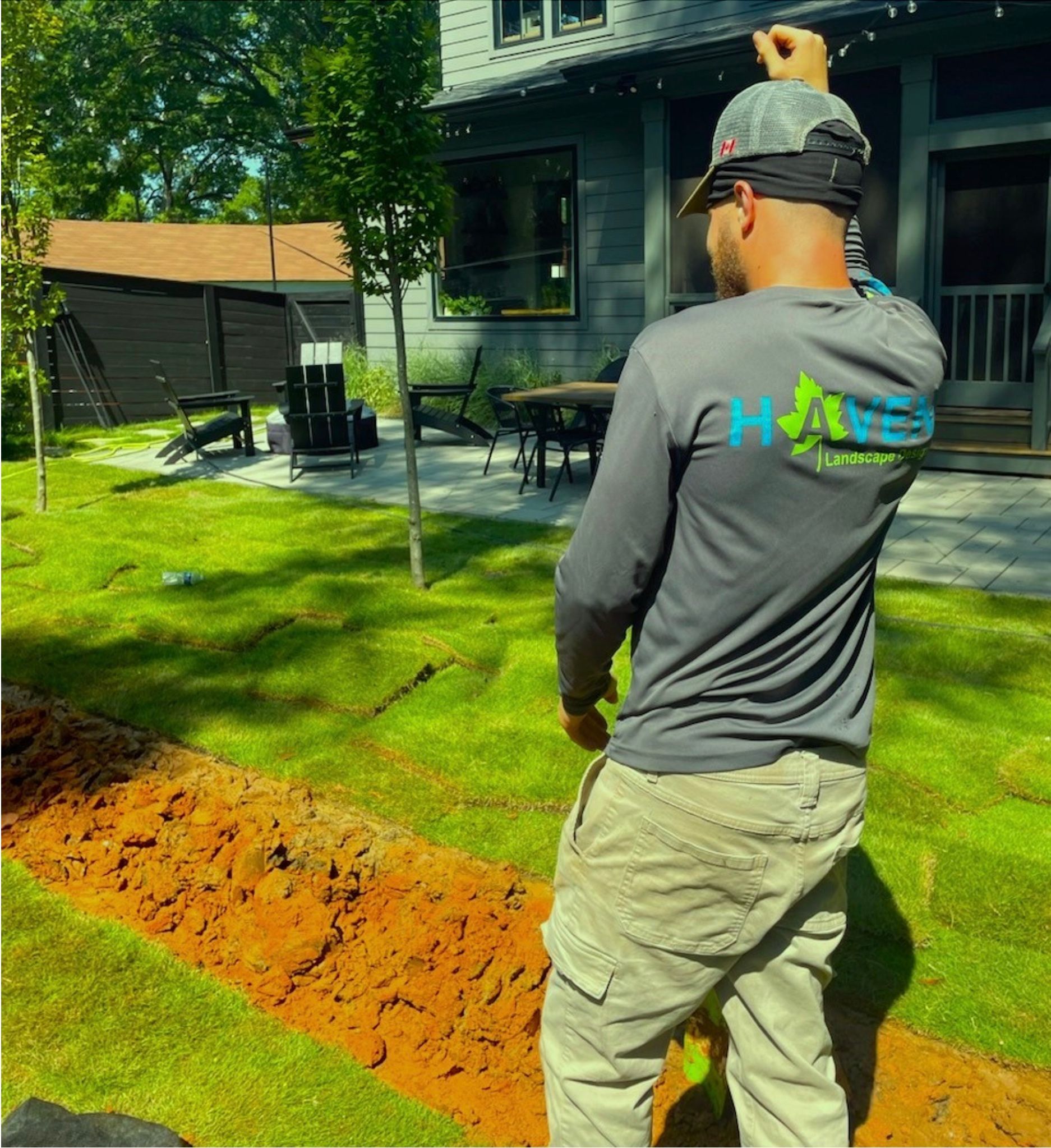 A lawn mower is digging a hole in the dirt in front of a house.