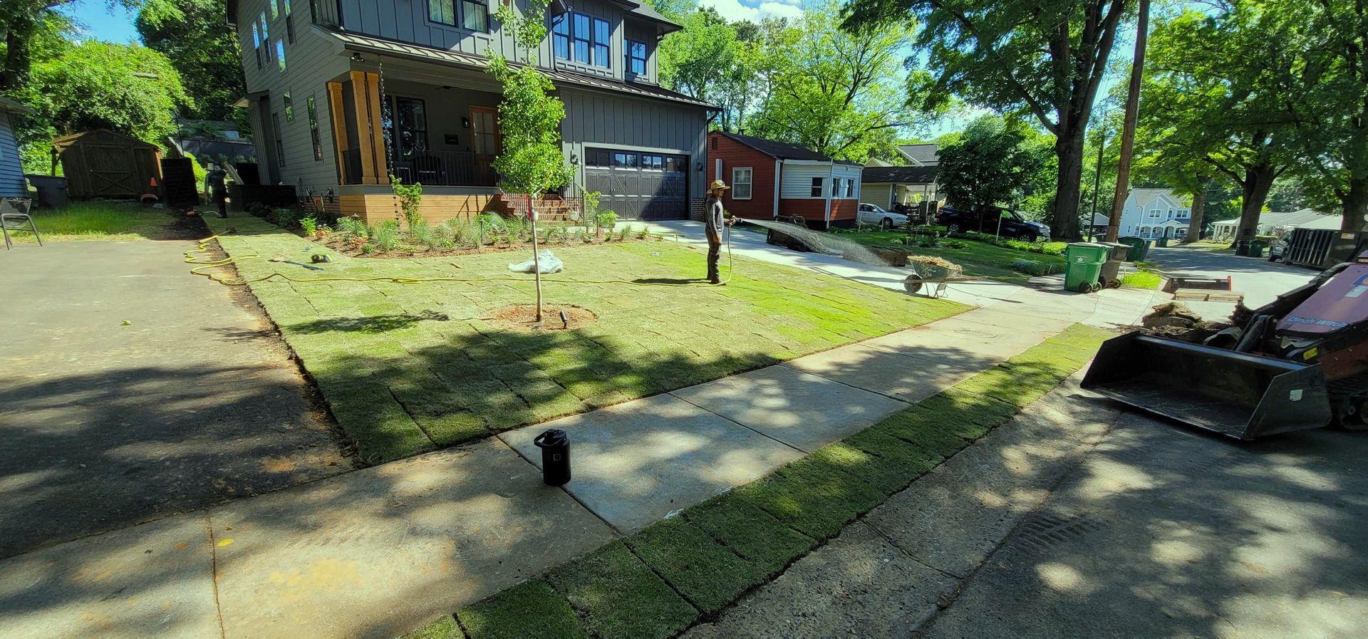 A lawn mower is sitting in a driveway next to a house.