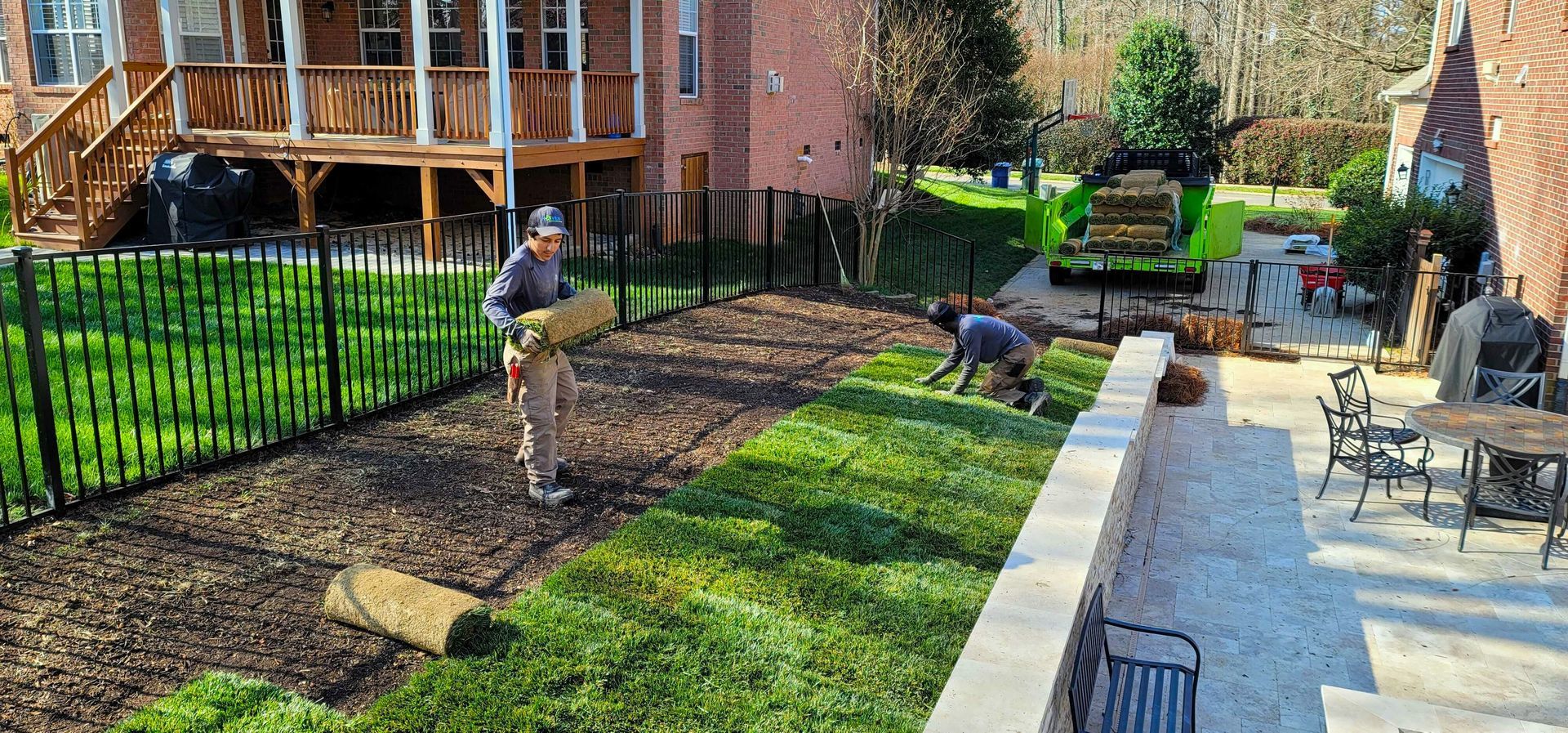 A man is working on a lawn in front of a house.