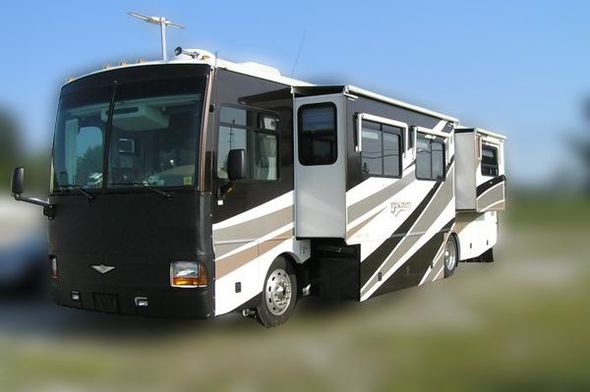 A large motorhome in an RV park with an extended slide out.