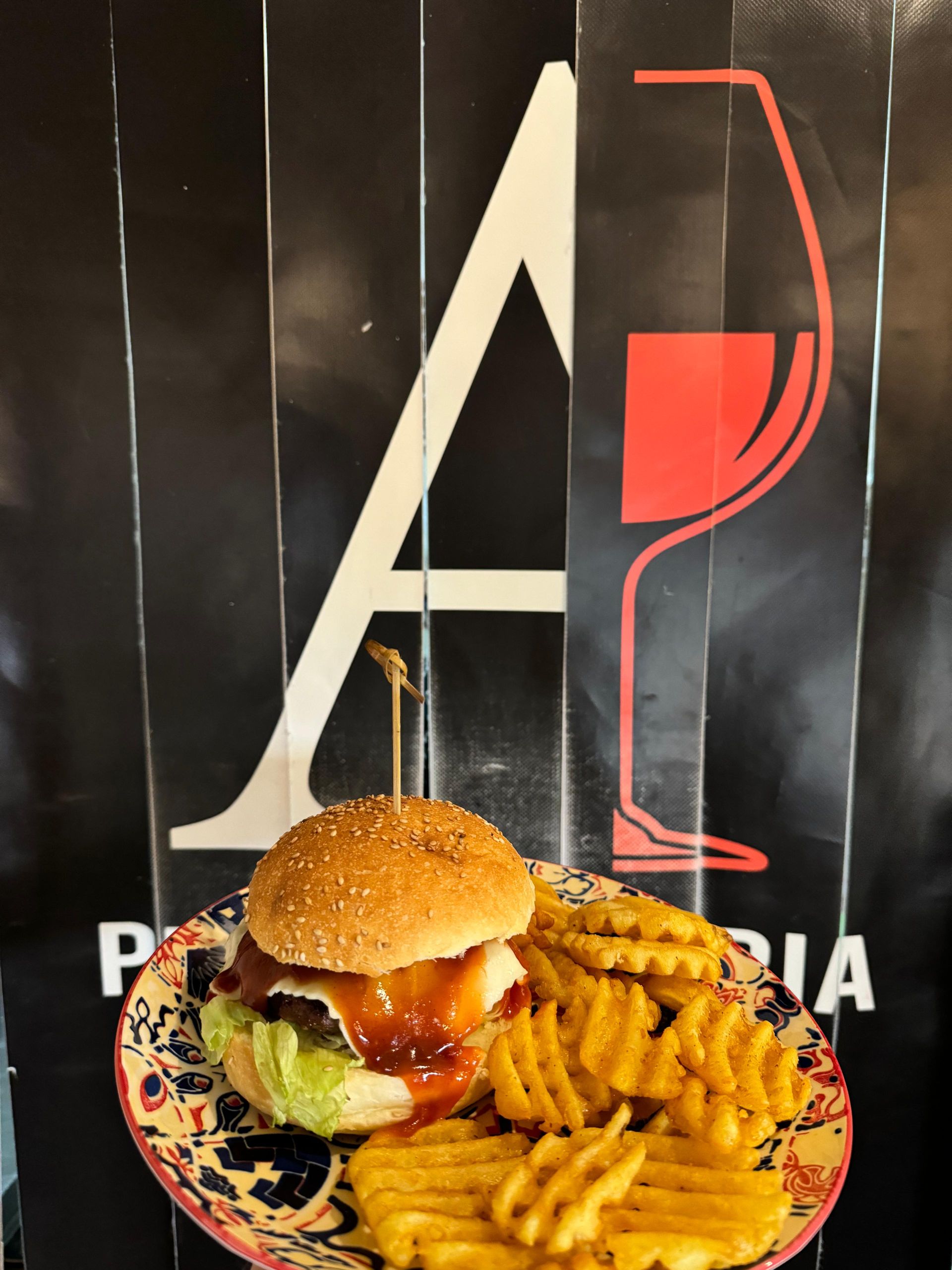 Un hamburger e patatine fritte su un piatto con la lettera a sullo sfondo