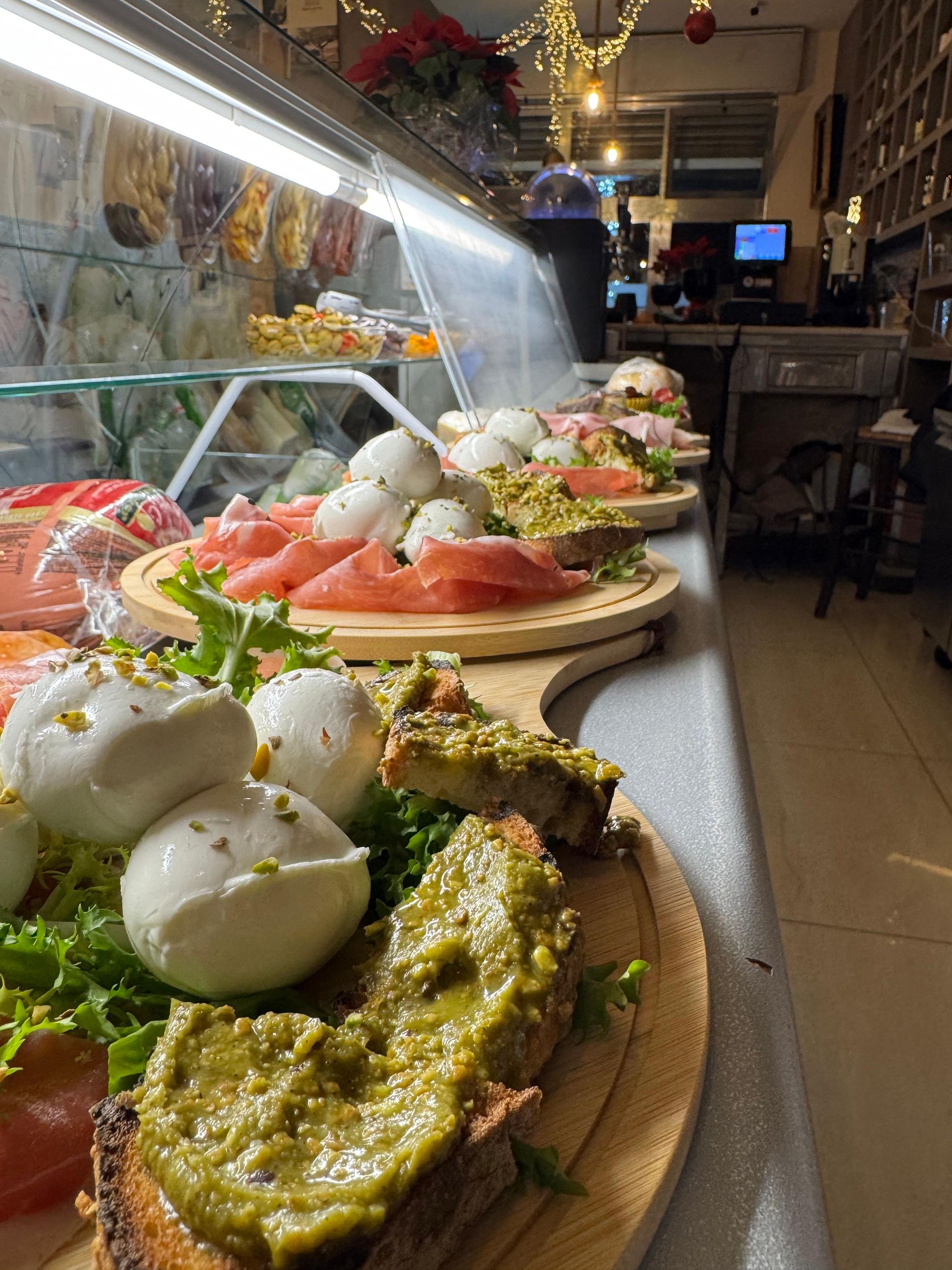 Un tagliere di legno con vari tipi di cibo sopra in un ristorante.