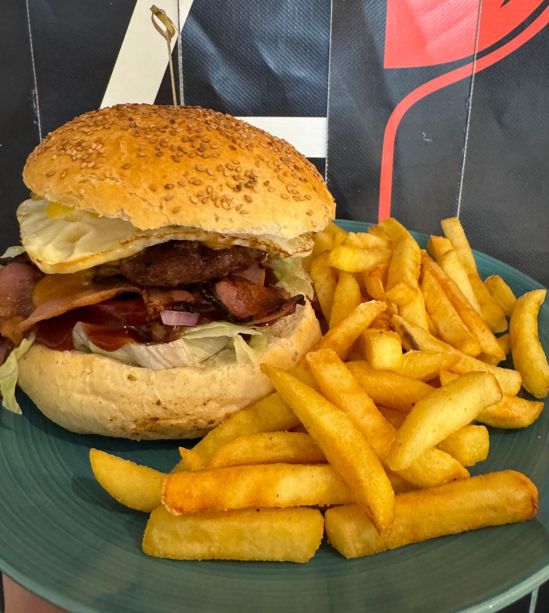 Un hamburger e patatine fritte su un piatto verde