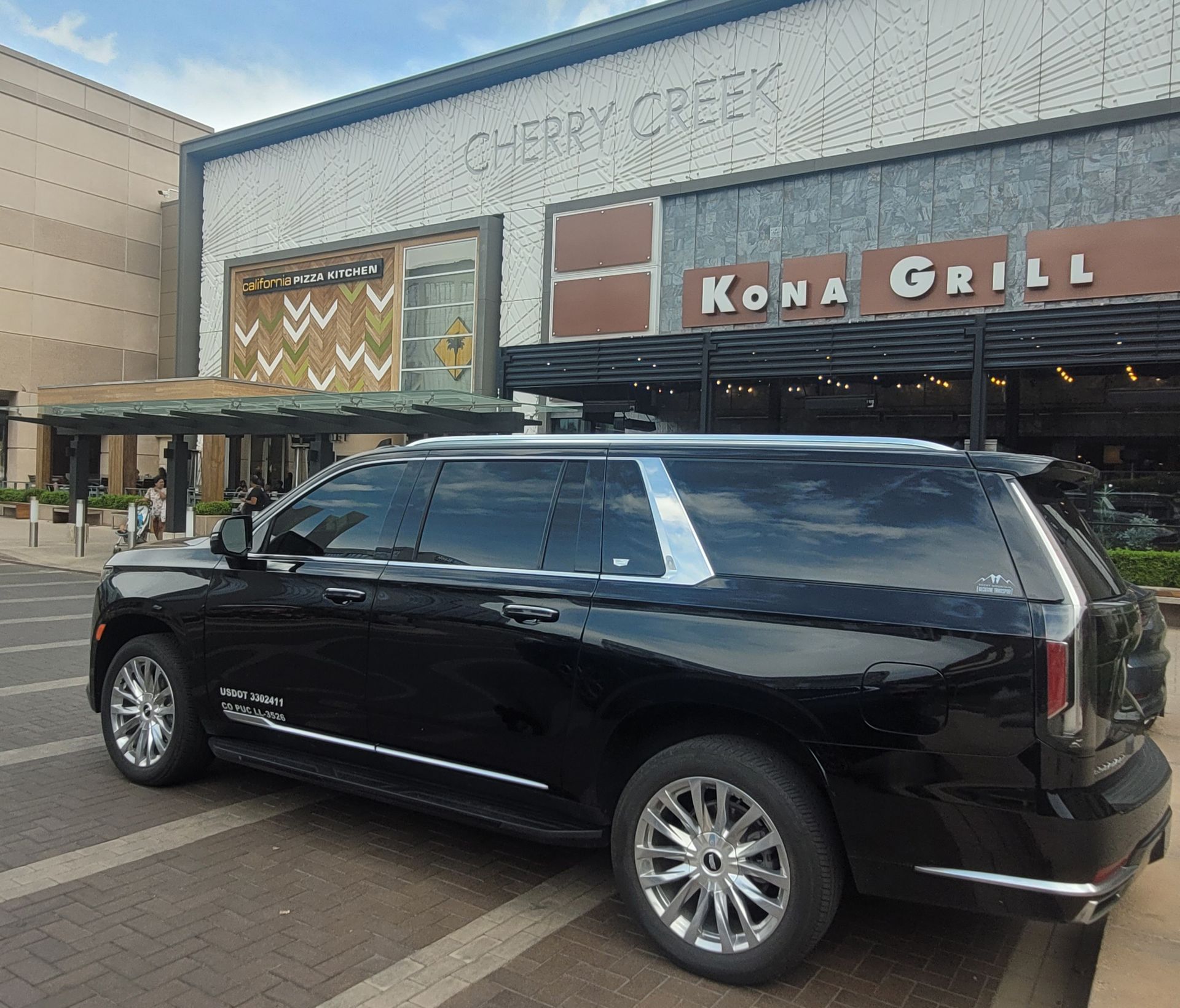 A black suv is parked in front of the kona grill