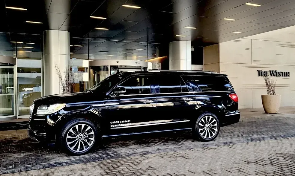 A black suv is parked in front of a building.