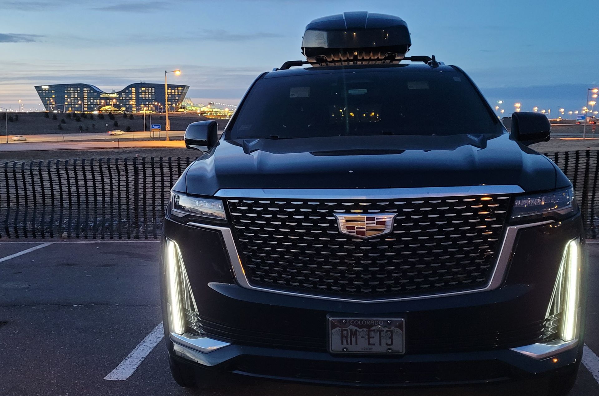 A black cadillac is parked in a parking lot