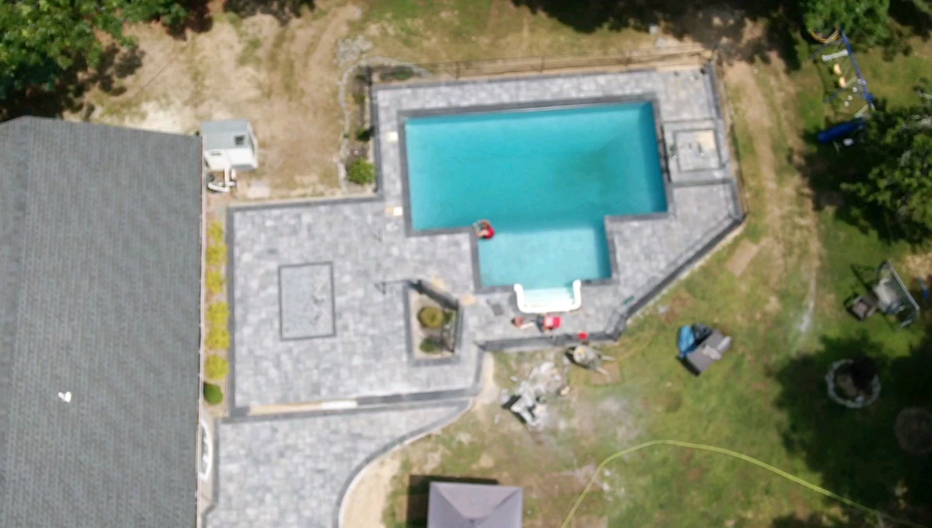 An aerial view of a swimming pool in a backyard.