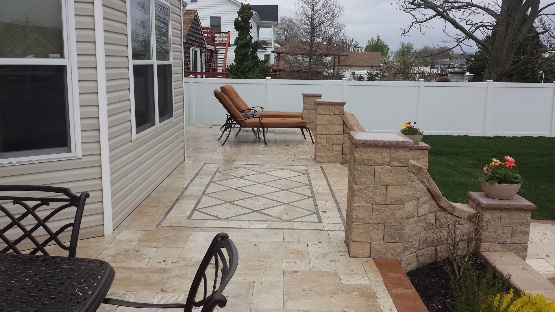 A patio with chairs and a table in front of a house