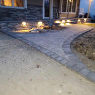 A walkway is being built in front of a house at night.