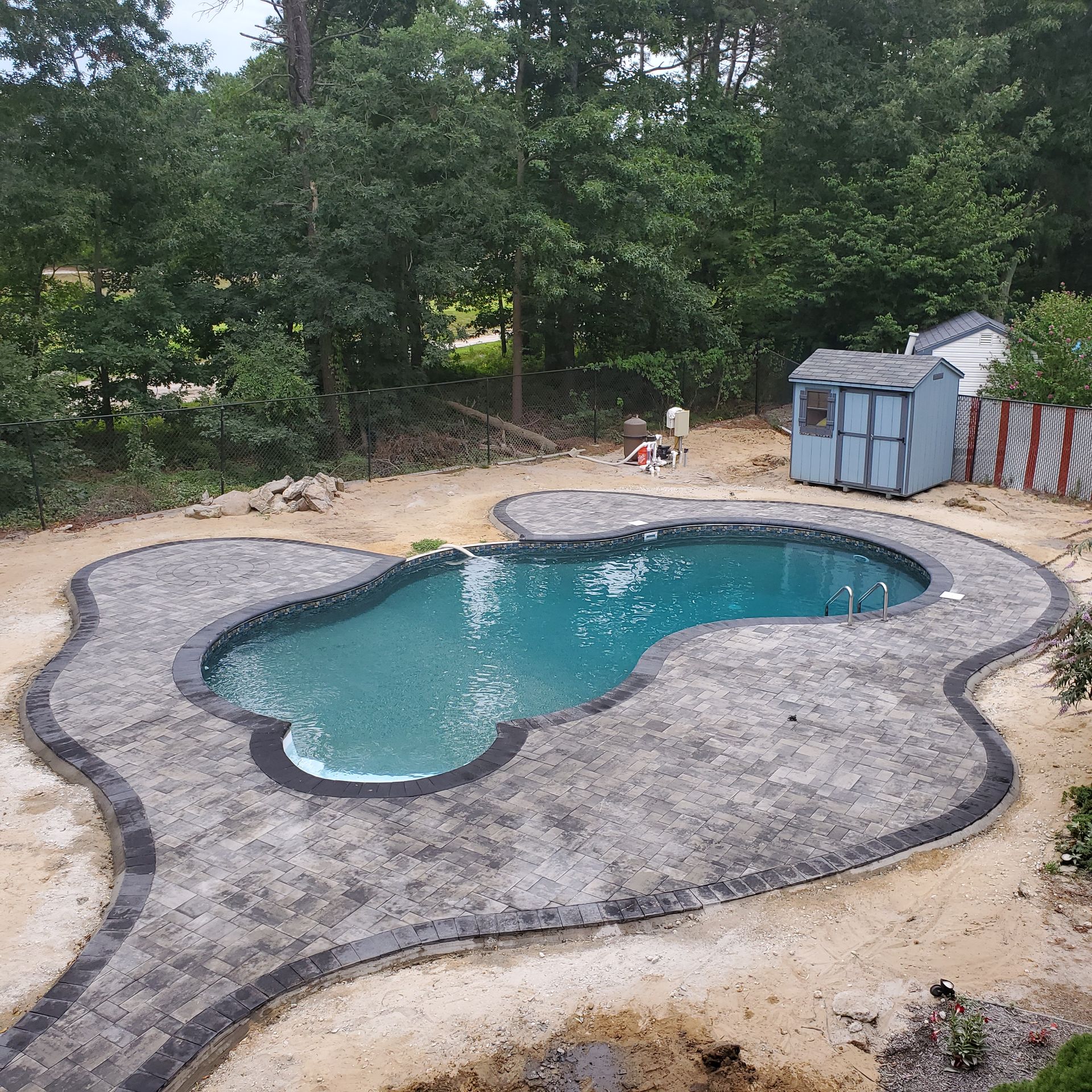 A large swimming pool with a shed in the background