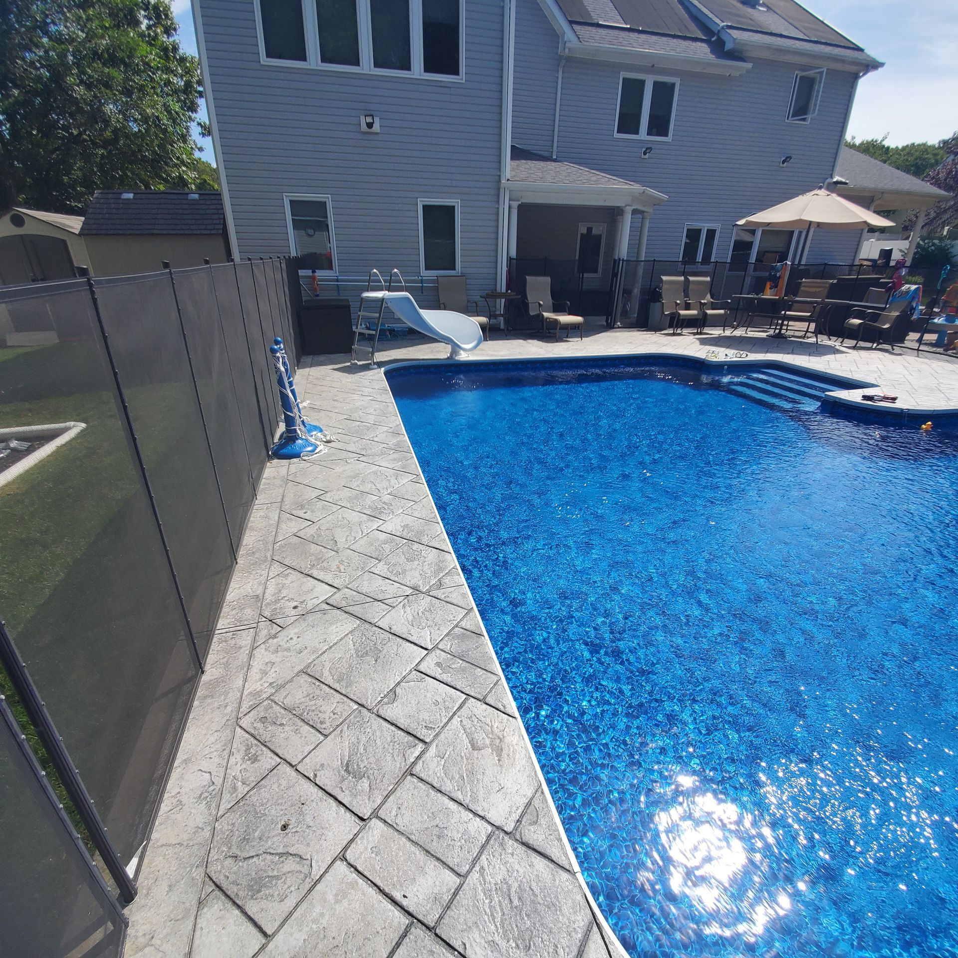 A large swimming pool with a house in the background