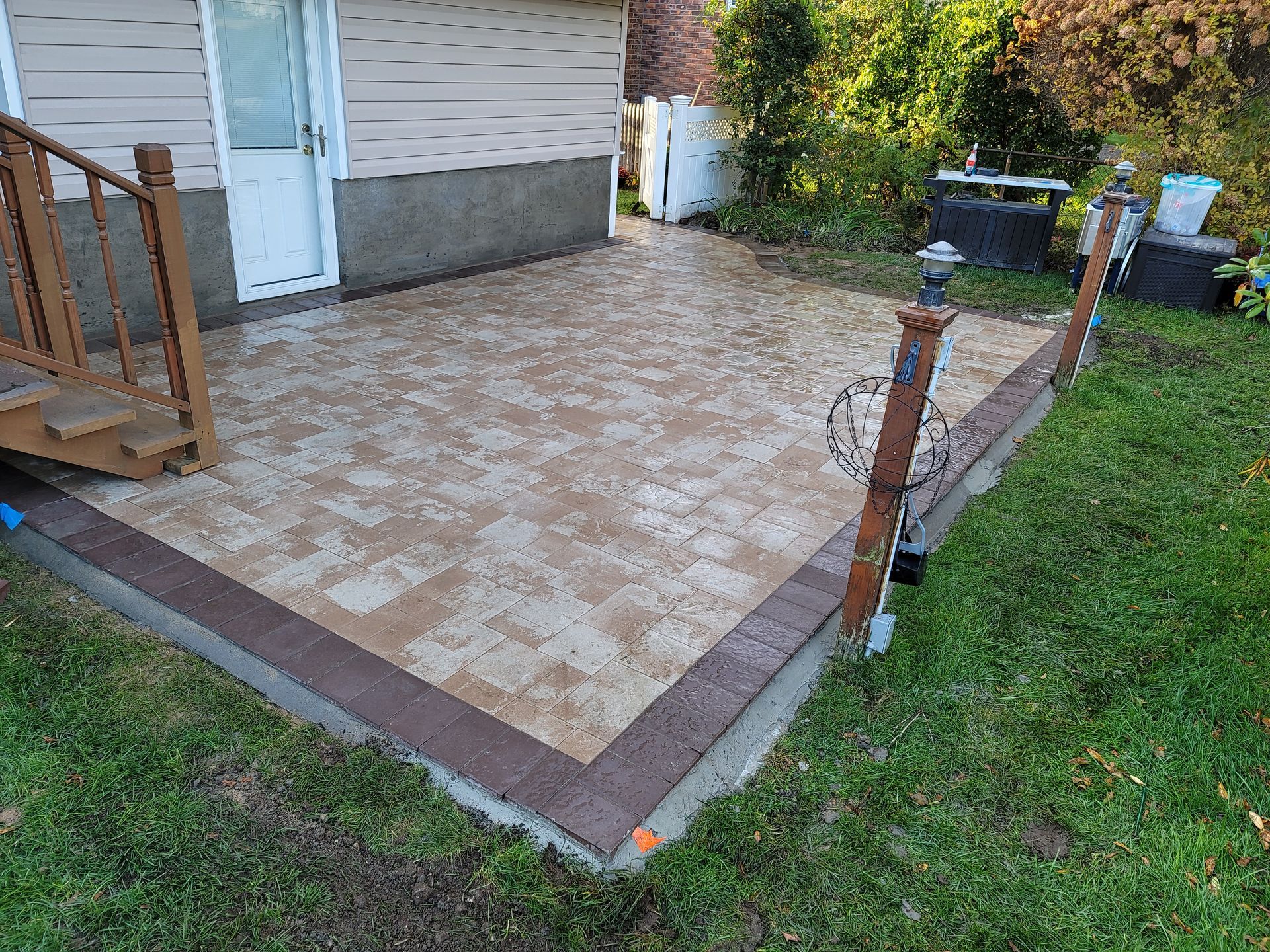 A patio with stairs and a fence in front of a house.