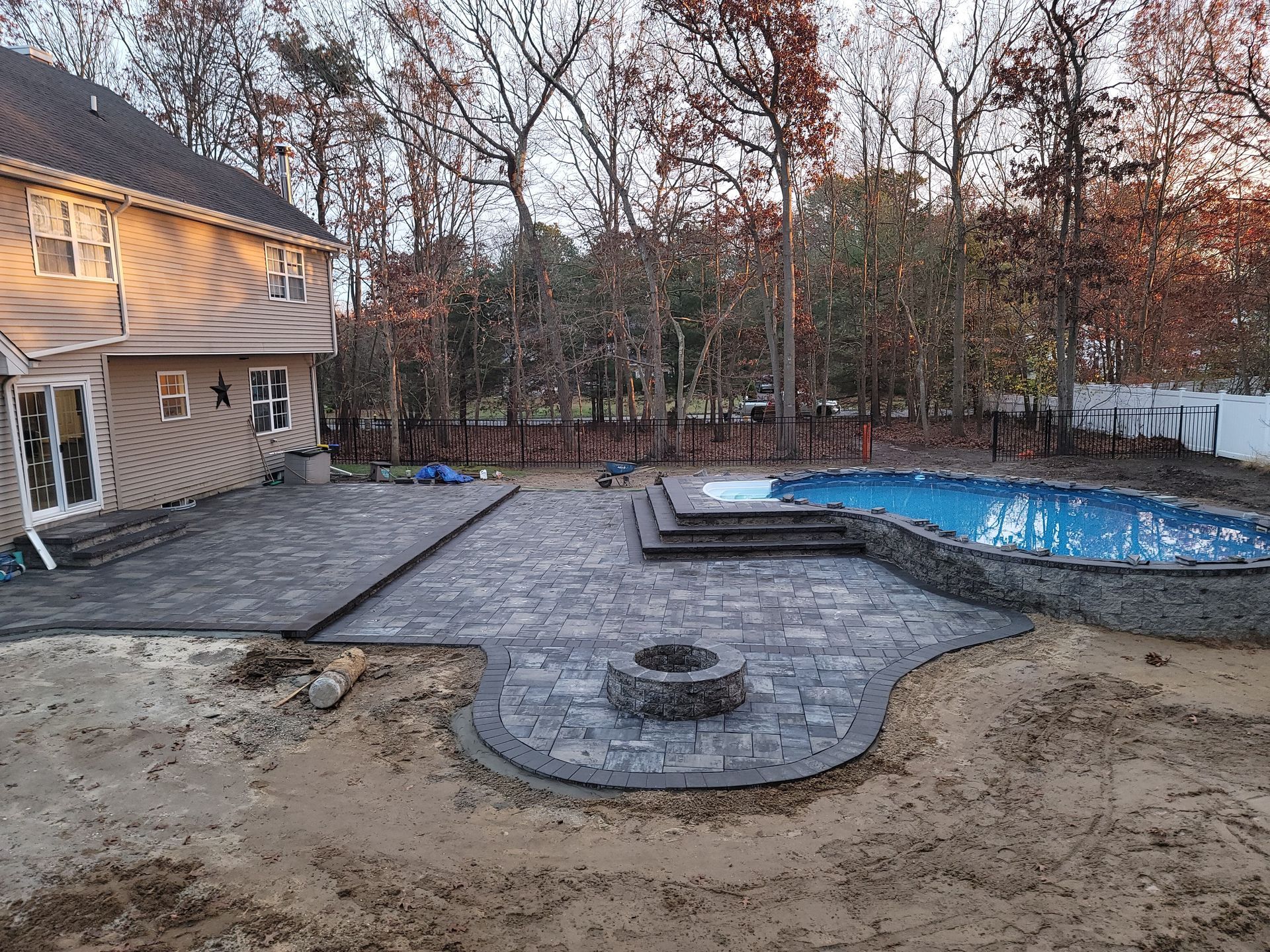 There is a large pool in the backyard of a house.